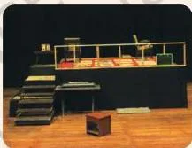 An empty stage set with two raised levels before the performance begins, posing the question of what each level implies for the audience