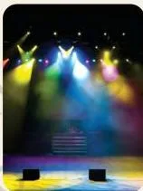 Coloured beams of light crossing over a dark theatre stage, visible only where the designer has aimed them