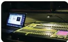 A lighting desk covered with buttons, faders and screens, the single control point for every light on stage