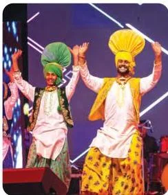 Bhangra performers celebrating in motion, the Punjabi folk music and dance tradition rooted in energetic dhol rhythms