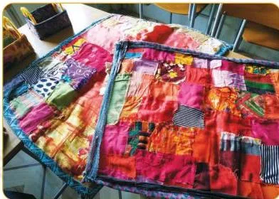A finished student-made patchwork quilt with its edges closed by another piece of cloth or by folding and stitching, completing Step 7