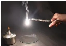 A magnesium ribbon burning with a bright white flame, leaving a white powder of magnesium oxide