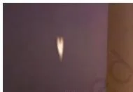 A candle flame in front of a cardboard sheet with a small hole, its inverted image forming on a screen