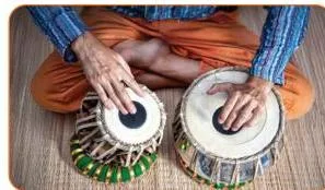 Close-up of a tabla player's hands on the drums, introducing the spoken bols of Ektaal that prepare the Saraswati Paran recitation.