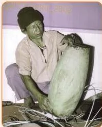 An instrument maker at work on a drum, representing the craft that keeps traditional art forms alive