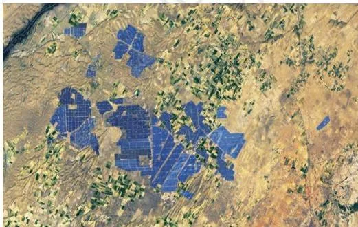 Satellite image of a vast solar park in Rajasthan, one of the largest in the world, seen from above as rows of panels in the desert