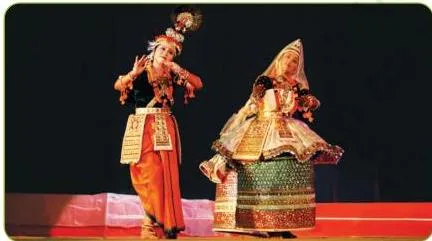 Manipuri dancer in the stiff poloi skirt and veil with a calm expression, feet together in a circular gliding movement