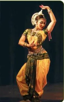 Odissi dancer in fan-shaped pleats and the tahiya headpiece, holding the tribhanga bend of head, torso and hip