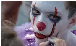 A mime performer in a neutral black and white costume with contrasting facial make-up, not a character costume