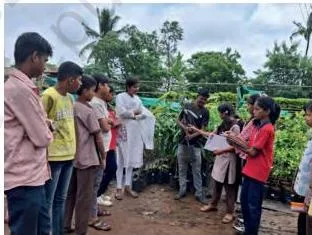 Students visiting a nursery to observe plants and talk with an expert while preparing for a nature walk