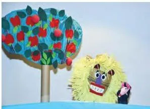 A paper lion puppet with a scared expression beside a sock mouse puppet, showing two materials in one scene