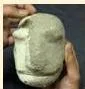 A papier-mâché puppet head being shaped with strips of pasted paper over a base